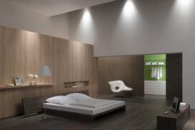 Schlafzimmerimpression mit Holzverkleidung an Wand Schlafzimmerimpression von Bett, Nachtisch und Sideboard mit Holzverkleidung an Wand und indirektert Beleuchtung